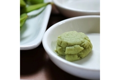 Image A white dish is holding green wasabi.