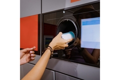 Image Woman placing empty can in DRS machine.