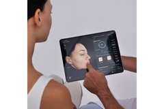 Image dermatologist shows a tablet to woman with analysis of her skin
