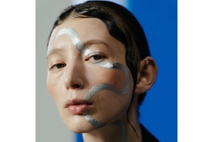 Woman's face with swirly line of paint across her face.