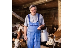 Image A dairy farmer standing and smiling.