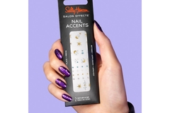 Image Manicured hand wearing cosmic patterns holding nail accent package.