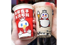 Image Two people are holding two cups of milk tea from Mixue.