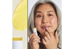 Woman holds product with her finger on her lip.