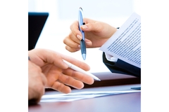 Image Two people signing a business deal.
