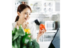 Image A female food technologist examining vegetables.