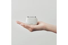 Image Panasonic's Palm Shaver in someones hand in front of a blue background.