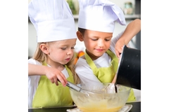 Image Two kids with chef hats on, cooking.