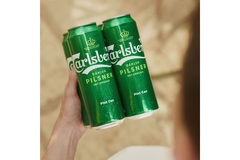 Person holding beer cans in bundle.