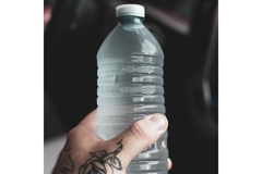 Image A person is holding a bottle of water.
