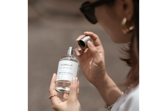 Image A woman opening a perfume bottle.