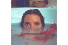 Image A womens face coming half out of the water in the bath.