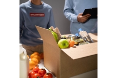 Image People gathering surplus food in cardboard boxes.