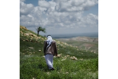 Iraqi farmer walking through nature.