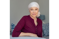 Image Woman with cancer who has a scarf around her head.