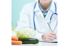 Doctor with vegetables on his desk.