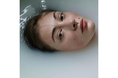 Image A womans face peeping out of milky water.