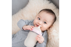Image Baby drinks milk from bottle.