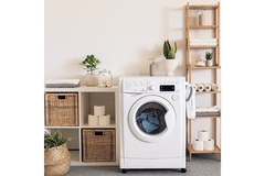 Image A laundry room with a washing machine in the middle.