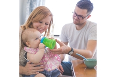Image Mother and father feeding their baby a bottle.