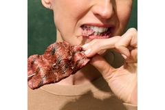 Image A woman takes a bite out of cell-based beef from Aleph Farms.