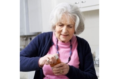 Old woman opening supplement bottle.