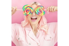Image A woman holding giant colorful lollipops over her eyes.