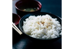 Image A bowl of rice is placed next to a bowl of soup.