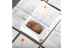 Cooked  chicken in paper-based packaging.