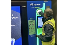 Image Man placing empty beverage bottle in reverse vending machine.