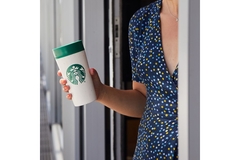 Image Woman holding reusable Starbucks cup.