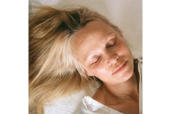 Image Pamela Anderson closing her eyes and lying down.
