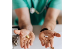 Image Doctor in scrubs holding out two different supplements in their hands.