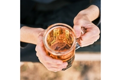 Image Hands holding beer glass.