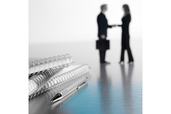 Image Silhouette of a man and woman shaking hands after a business deal.