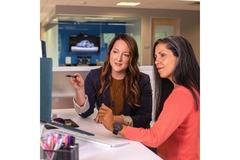 Image Two women looking at a computer and talking.