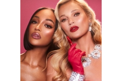 Image Two models wearing and holding lipstick.