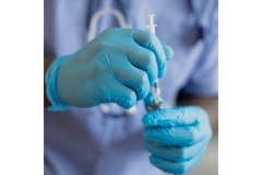 Man wearing medical gloves preparing injection.