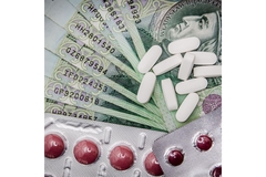 Image Different pills lying on top of dollar bills.