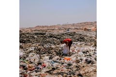 child at a dumpsite collecting waste
