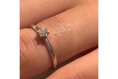 Image finger with ring and transparent tattoo around it.