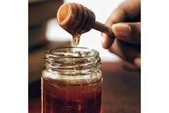 Image A can of honey is on the table.