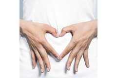 Image Two hands in a shape of a heart on the gut.