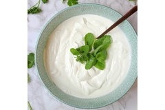 Image A piece of mint it put on a bowl of yogurt.