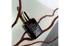 Image Estee Lauder serum on a branch.