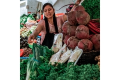 Woman sales vegetables at market.