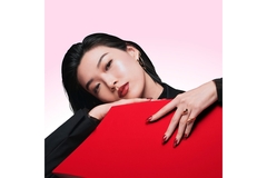 Image A woman leaning on a red couch.