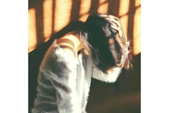 Image A person holds their head in pain.