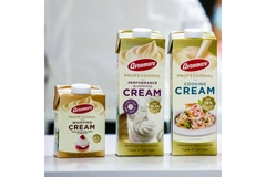 Image Boxes of Tirlán's products are lined up on the table.