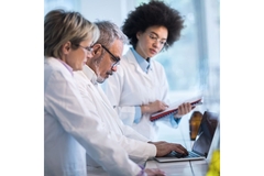Group of researchers behind a computer searching for microbes with the MicrobeMASST tool.